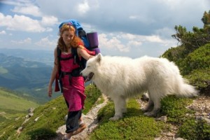 Backpacker girl travelling in the Carpathian mountains with dog